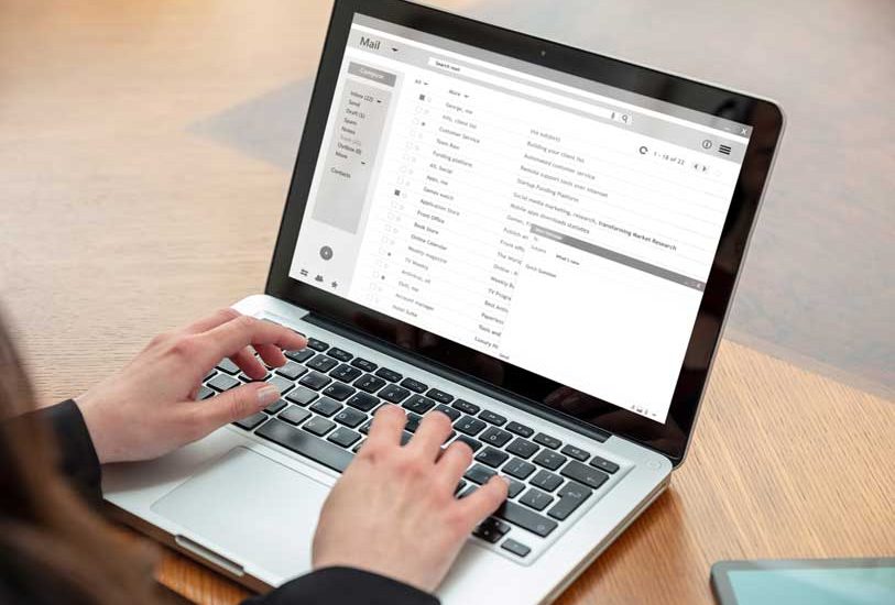 handing typing on a laptop keyboard showing email